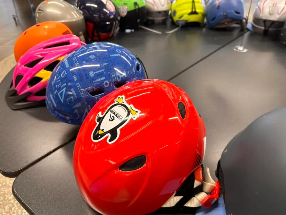 Brightly colored kids’ bike helmets on a sale table