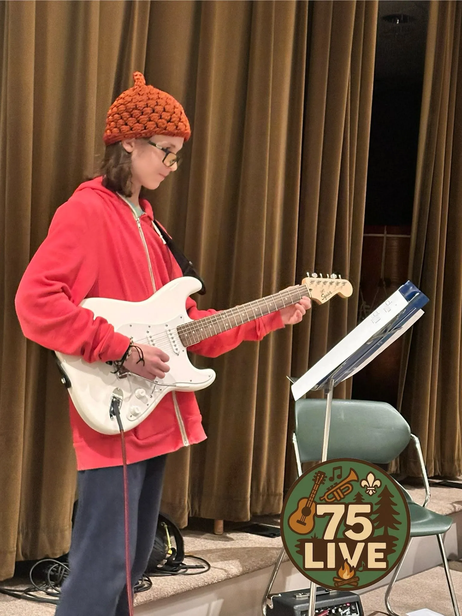 A young 75 Live guitarist performing