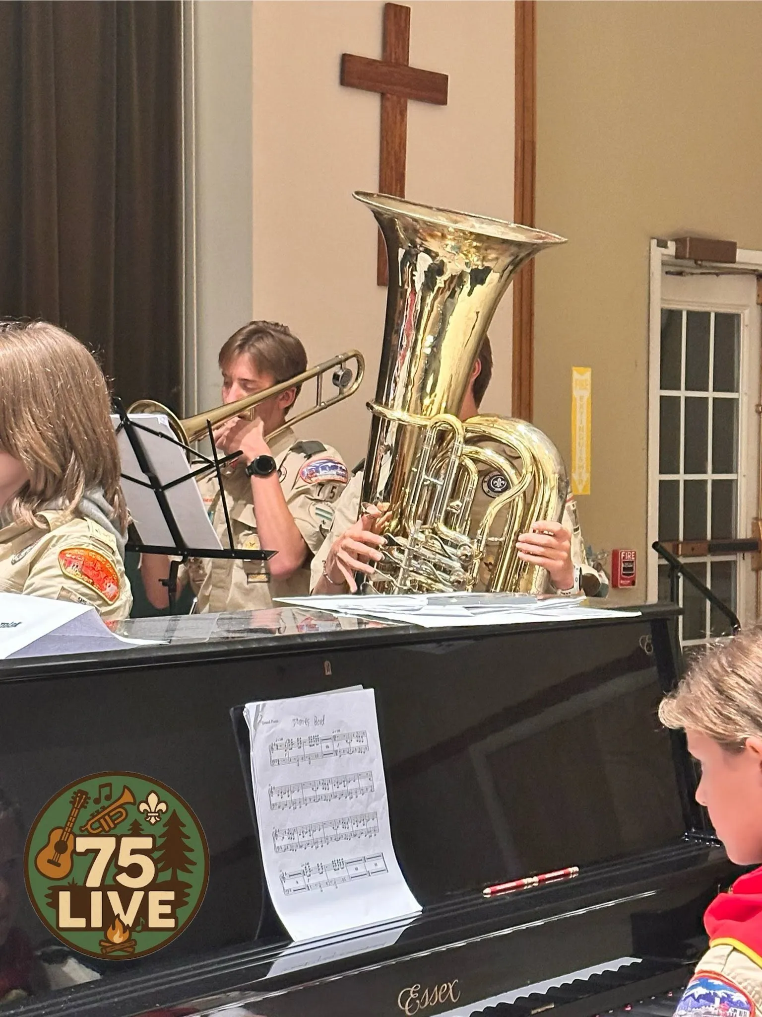 Scouts in uniform playing tuba and trombone with 75 Live