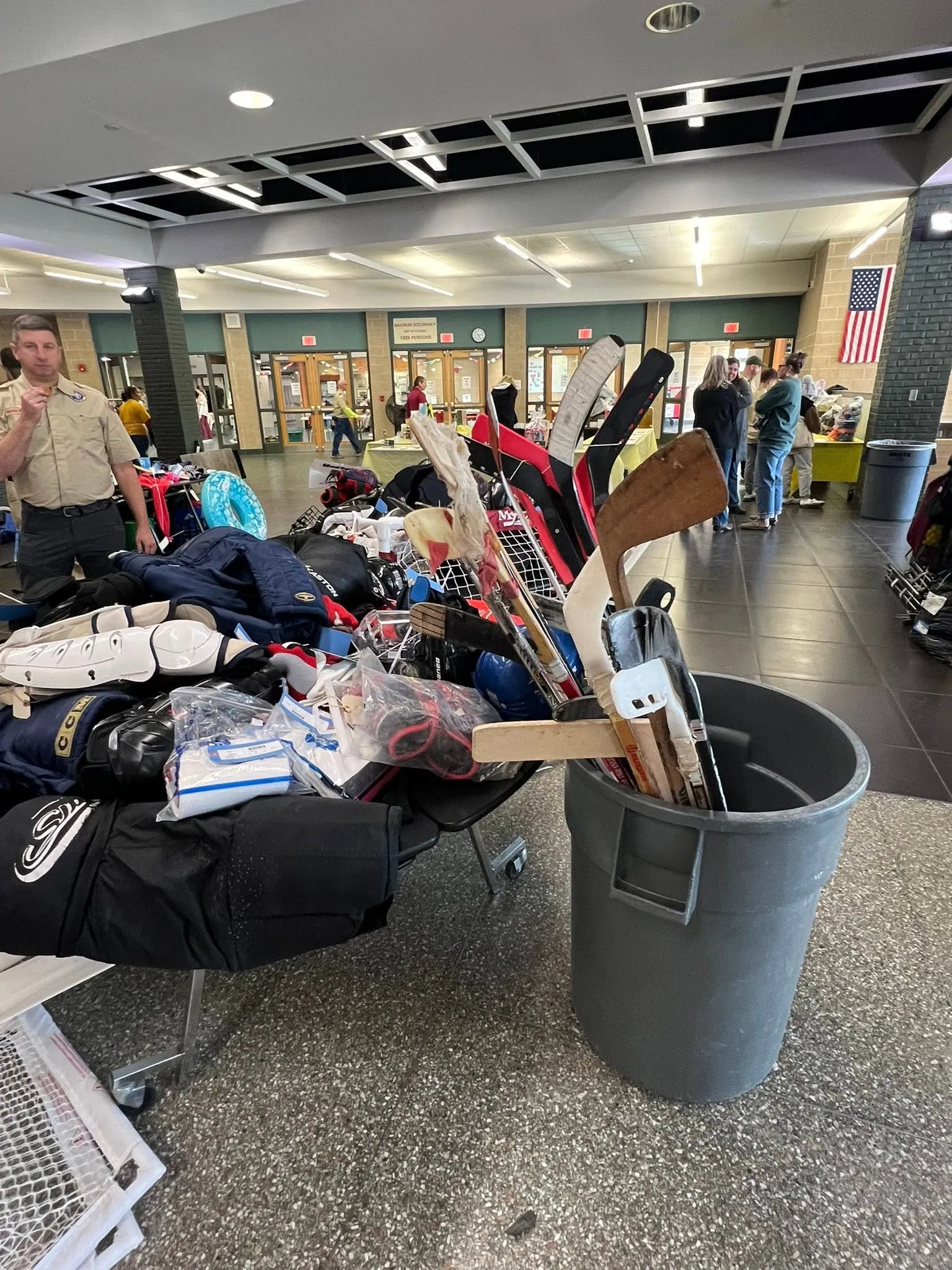 Hockey sticks, goalie pads and gloves piled on a sale table