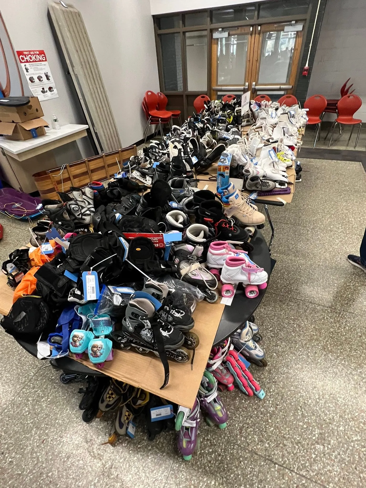 A long table covered with ice skates and roller skates
